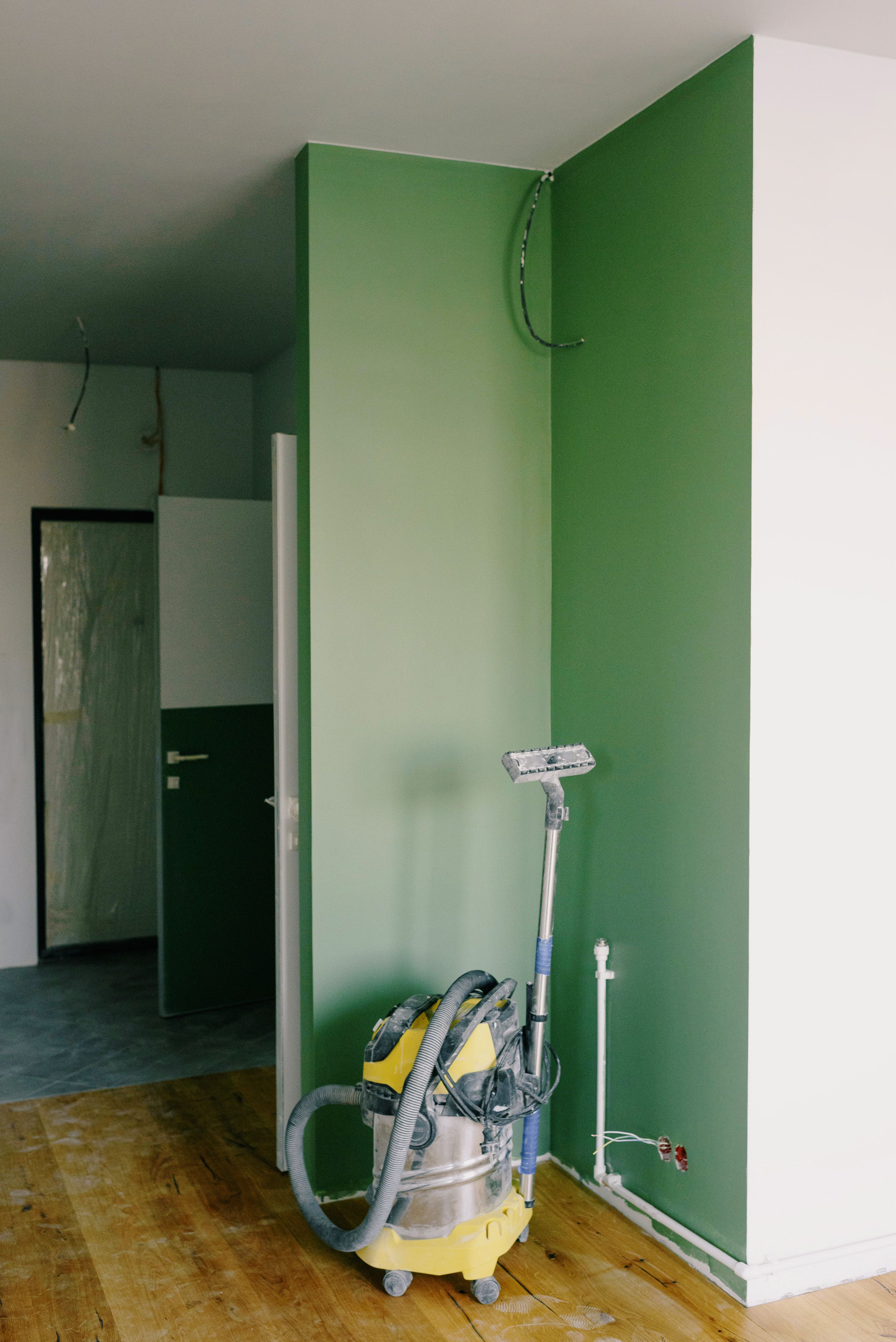Peinture soignée de mur vert et aspiration continue pour un chantier sans poussière